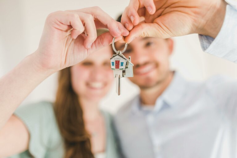 Ein Paar hält den Schlüssel Ihres gekauften Hauses in den Händen